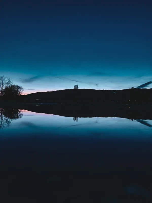 a large body of water with a mountain in the background